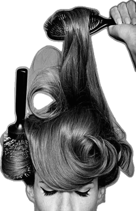 A stylist lifting a section of hair with brushes